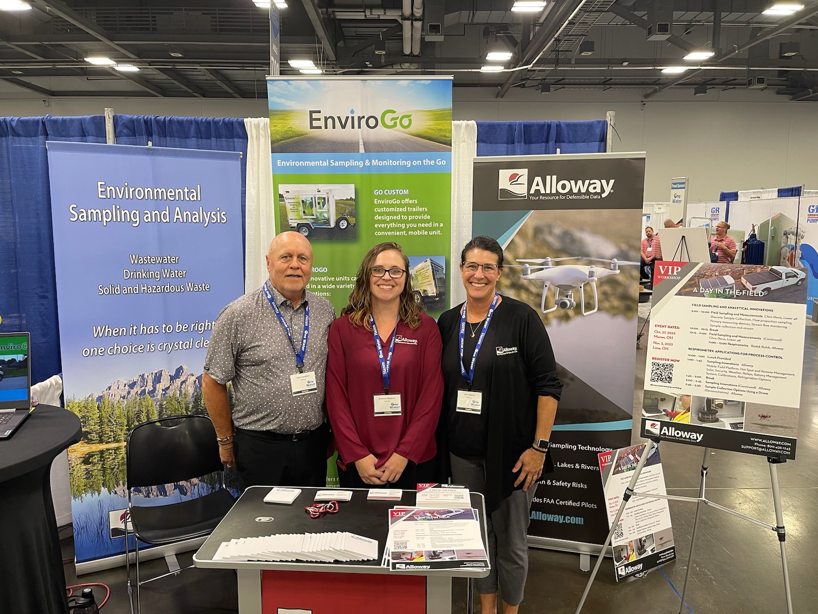 Gary Lockhart, Julie Bigford and Amanda Retterer standing in front of their booth at the One Water Conference